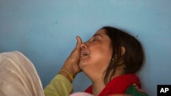 A woman tries to comfort wife Ankita Sharma as they await the arrival of the body of Indian paramilitary soldier Sanjay Kumar at his home in Palampur, about 40 kilometers south of Dharmsala, India.