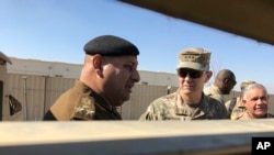 El teniente general del ejército estadounidense Stephen Townsend (centro a la derecha) habla con un militar iraquí durante una visita a un área del norte de Bagdad. Feb. 8, 2017. 