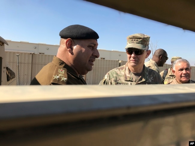 FILE - U.S. Army Lt. Gen. Stephen Townsend, center right, speaks with an Iraqi officer during a visit to an area north of Baghdad, Feb. 8, 2017.