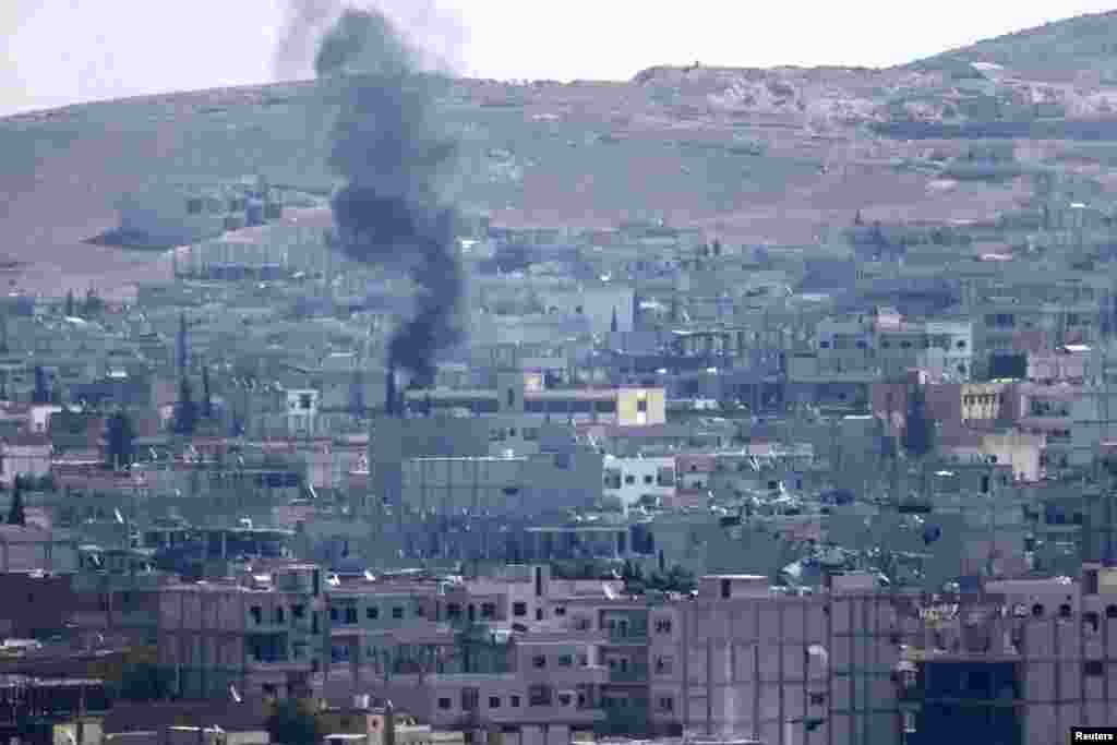 Smoke rises over the Kobani, as seen from the southeastern town of Suruc, Turkey, Oct. 24, 2014.