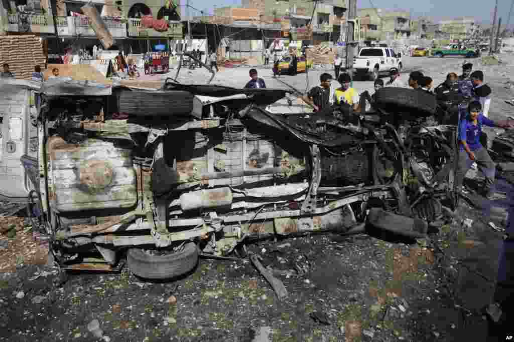 Iraqis inspect the aftermath of a car bomb attack, in the Shi'ite enclave of Sadr City, Baghdad, July 29, 2013.