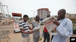 Dan Nigeria ke karanta jaridar dake dauke da kanun tada bom da ya halaka wata mace jami'ar 'yan sanda da kuma wasu mutanen su 10 a Abekuta, Nigeria. Gungun jami'an kallo, ke bayyana cewar zagayen farko daga cikin zagaye ukun zaben da za'a yi a Nigeria n