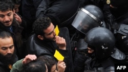 Les manifestants face aux forces de sécurité bloquant l'accès aux bureaux du gouvernorat à Tunis, le 12 janvier 2018