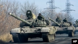 Pro-Russian rebel military vehicles convoy move towards Donetsk , Eastern Ukraine, Monday, Nov. 10, 2014. On Saturday, Associated Press reporters saw scores of military vehicles moving near Donetsk and farther to the east. Many of the unmarked vehicles we