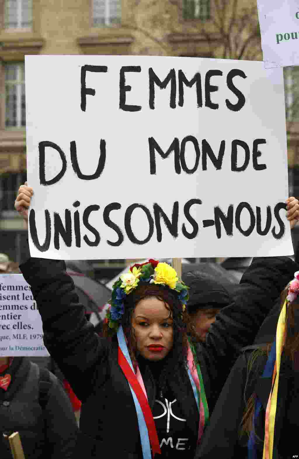 Une Femen tient une pancarte &quot;Les femmes du monde s&#39;unissent&quot; sur la place de la République, lors de la Journée internationale des droits des femmes, à Paris, le 8 mars 2018.