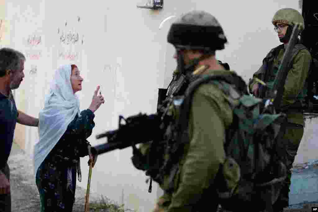 A Palestinian relative of Zakariah al-Aqrah, 21, who was killed during an operation by Israeli troops, speaks to soliders in the West Bank village of Qabalan near Nablus. The Israeli military said it killed Al-Aqrah, a suspected Palestinian militant, after he opened fire on an Israeli force.