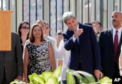 El exsecretario de Estado John Kerry junto a la directora general de la división de EE.UU. en Ministerio de RR.EE. de Cuba durante la ceremonia de izada de la bandera en la reapertura de la Embajada de EE.UU. en La Habana. Agosto 14 de 2016.