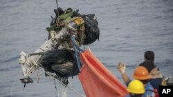 Los rescatistas usan la grúa para recuperar parte de los trenes de aterrizaje del avión Lion Air que se estrelló del fondo marino en las aguas de Tanjung Karawang, Indonesia, domingo 4 de noviembre de 2018.