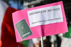 Pendukung 'No Vax' mengangkat spanduk dalam aksi unjuk rasa menentang pengenalan wajib "Green Pass" di Piazza del Popolo, Roma, 7 Agustus, 2021. (Alberto PIZZOLI /AFP)