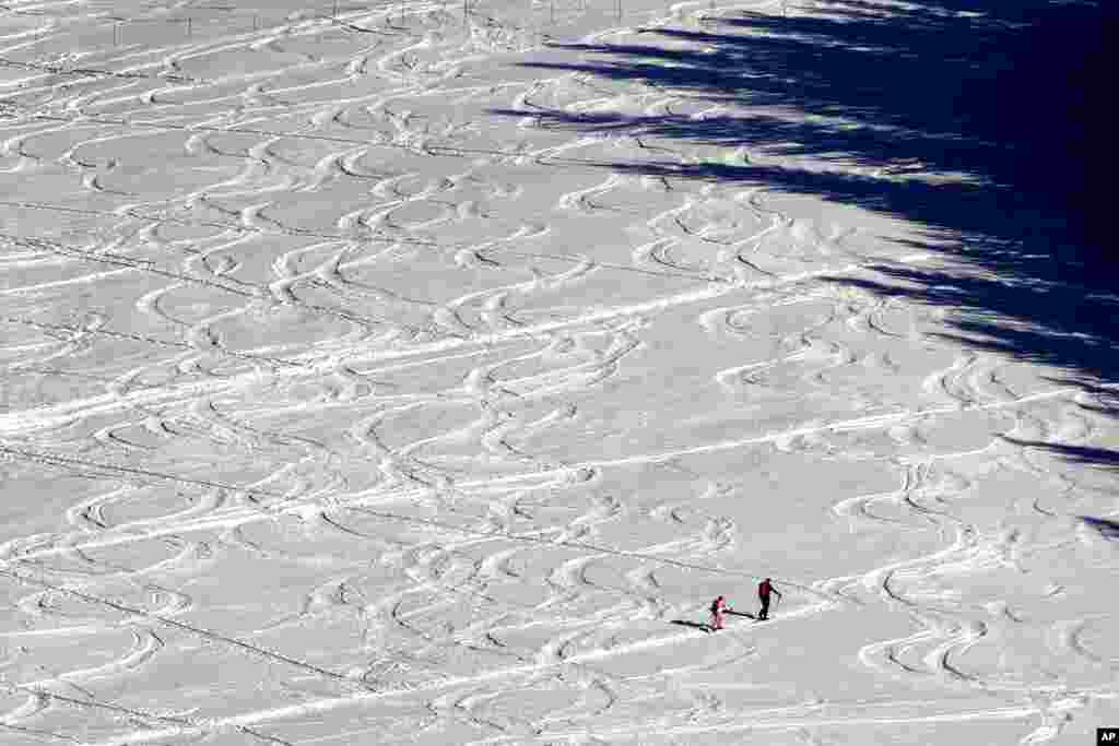 Skiers make their way through a snow-covered landscape near Filzmoos, Austria.