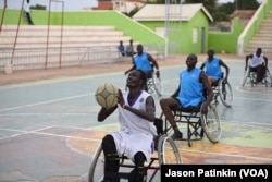 A wheelchair basketball player puts his artificial leg back on after a game at a basketball court in Juba, South Sudan, May 31, 2016.