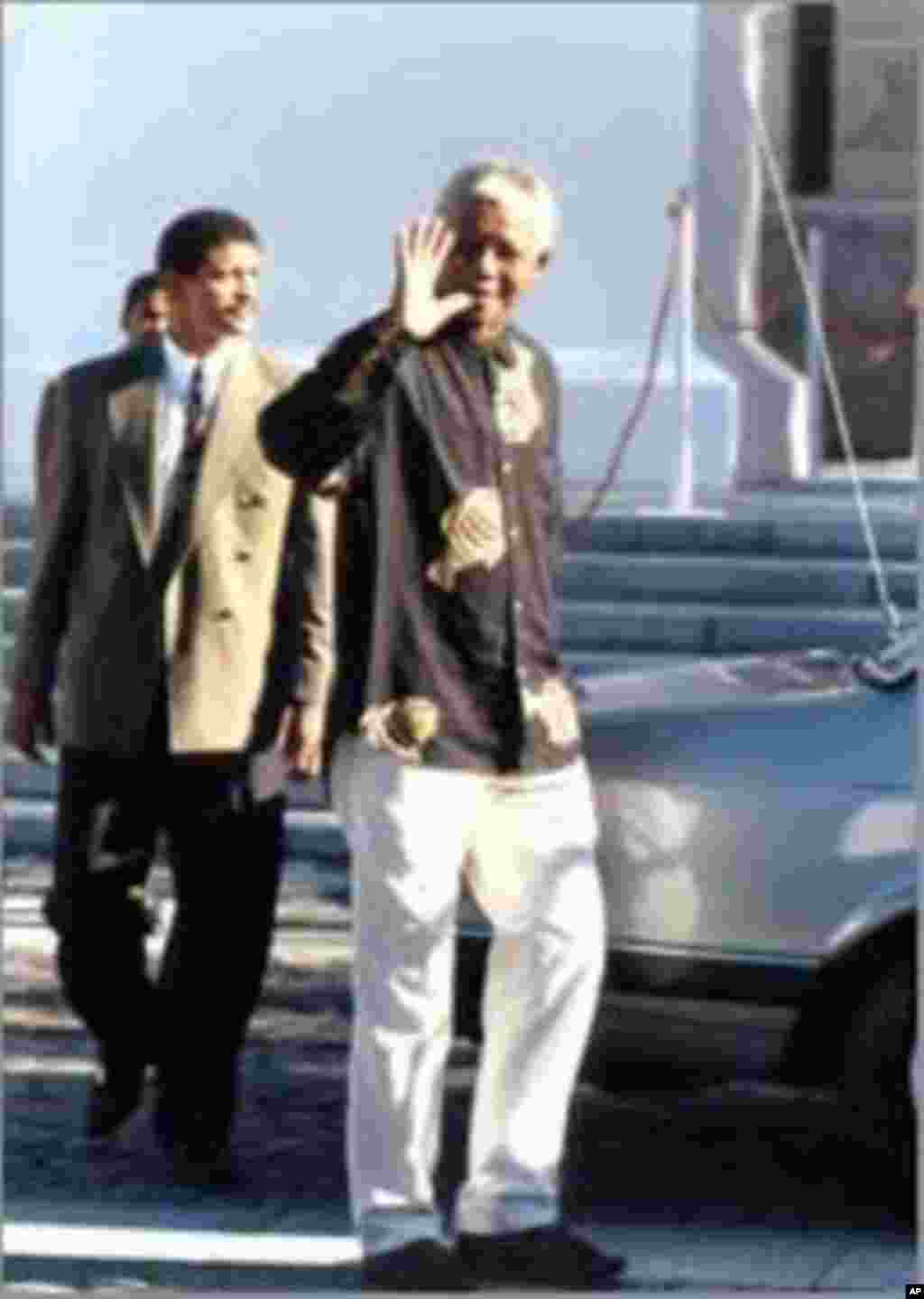 Nelson Mandela waves to supporters shortly before being inaugurated as South Africa’s first democratic president … He’s wearing his very first ‘Madiba shirt,’ given to him by Cape Town fashion designer Desre Buirski