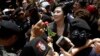 Thailand's former Prime Minister Yingluck Shinawatra, center, receives a flower from her supporter at the Supreme Court after making her final statements in a trial on a charge of criminal negligence in Bangkok, Thailand, Aug. 1, 2017.