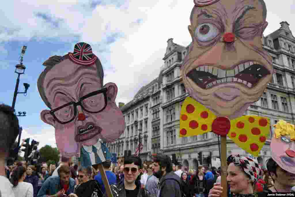 Pro-European Union protesters wave banners ridiculing pro-"Leave" Conservative Michael Gove and United Kingdom Independence Party leader Nigel Farage, July 2, 2016.