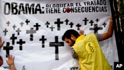Activistas de Amnistía Internacional cuelgan un cartel frente a la embajada de Estados Unidos en México.