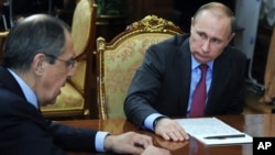 Russian President Vladimir Putin, right, listens to Russian Foreign Minister Sergey Lavrov during their meeting in the Kremlin in Moscow, Russia, March 14, 2016. 