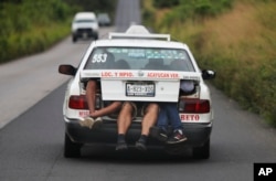Central American migrants, part of the caravan hoping to reach the U.S. border, a ride on in the trunk of a taxi, in Acayucan, Veracruz state, Mexico, Nov. 3, 2018.