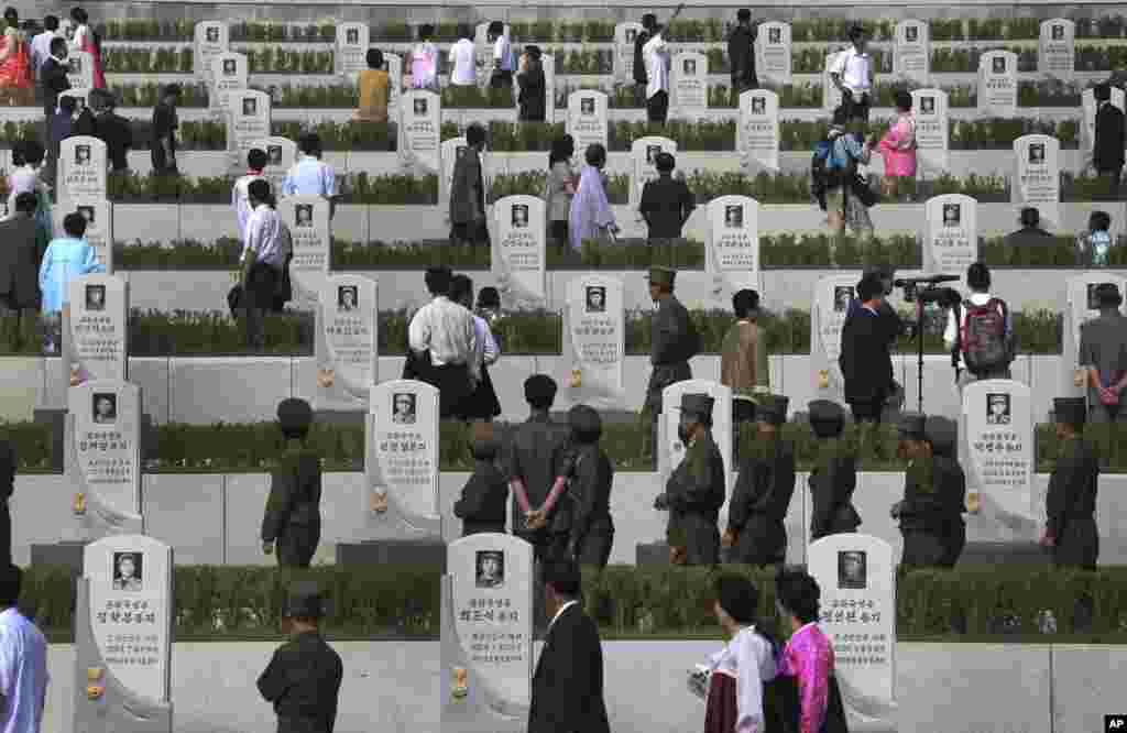 North Koreans walk among tombstones of soldiers who died during the war to pay their respects as celebrations begin to mark the 60th anniversary of the end of the Korean War, Pyongyang, July 25, 2013.