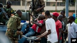 Pasukan penjaga perdamaian Uni Afrika dari Kamerun mengangkut seorang yang terluka dalam kerusuhan di Bangu (29/5). 