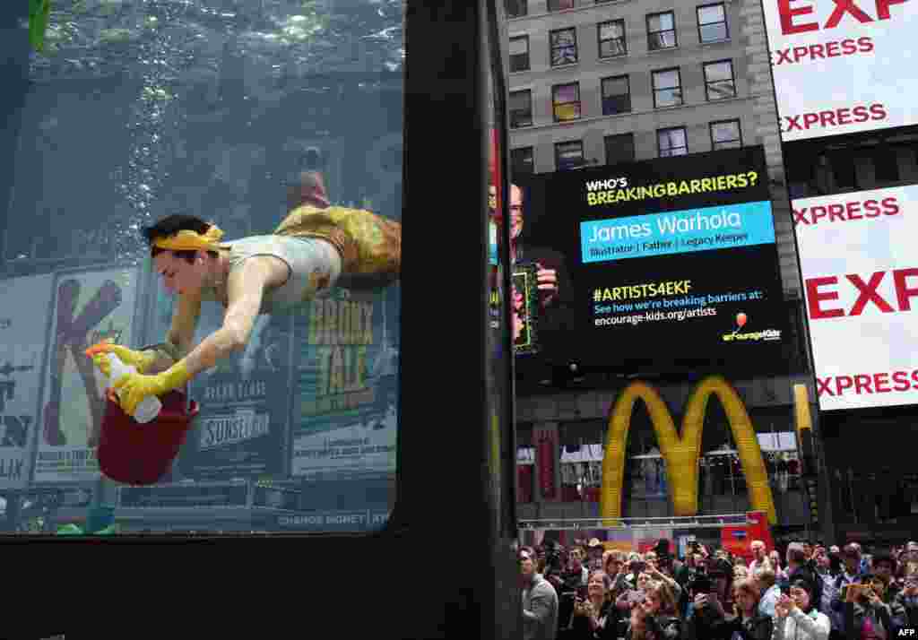 Artis Annie Saunders melakukan akting sebagai petugas kebersihan dari sebuah aquarium di Times Square, New York.