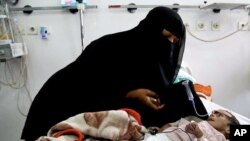 In this Tuesday, March 22, 2016 photo, Udai Faisal, who is suffering acute malnutrition is fed by his mother Intissar Hezzam at al-Sabeen Hospital in Sana'a, Yemen. Hunger has been the most horrific consequence of Yemen’s conflict and has spiraled since Saudi Arabia and its allies, backed by the U.S., launched a campaign of airstrikes and a naval blockade a year ago. 