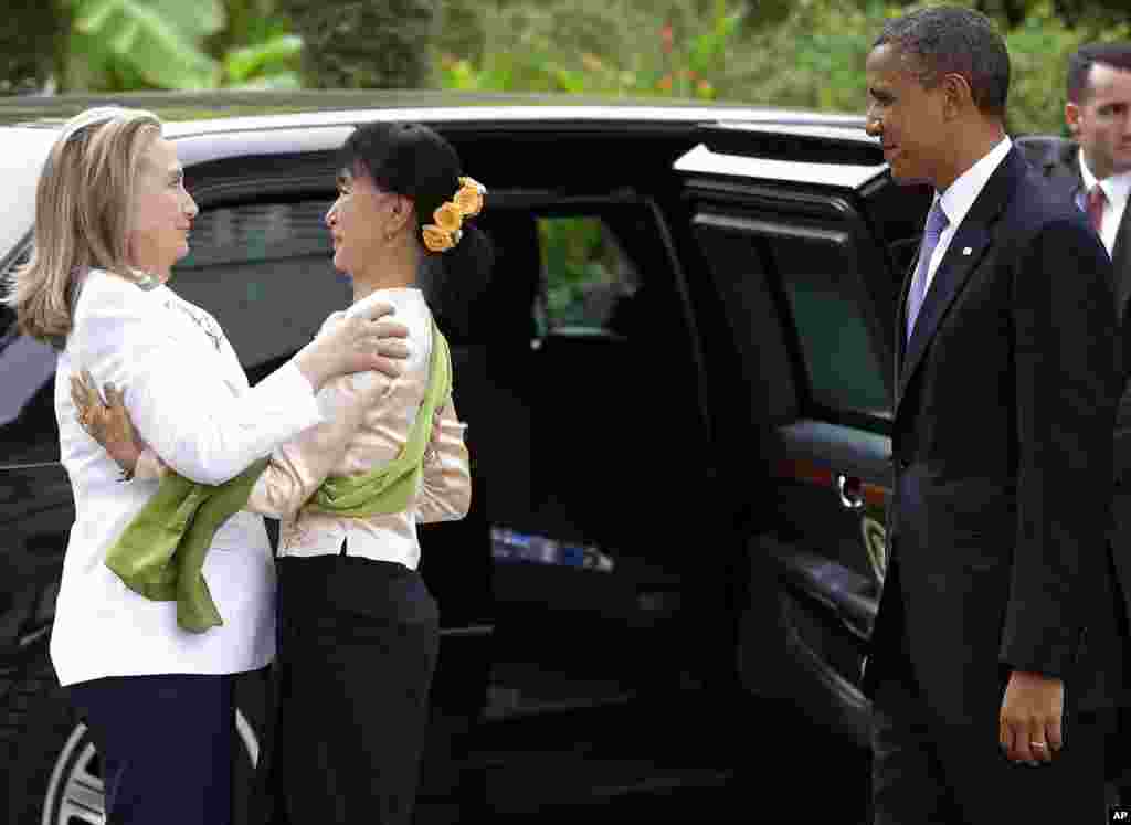2012年11月19日，昂山素季（中）在仰光迎候美国国务卿希拉里.克林顿，美国总统奥巴马在旁观看。