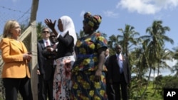 U.S. of State Hillary Rodham Clinton listens to with Halima Abubakary, white scarf, while talking with farmers of the Upendo Women's Cooperative in Mlandizi, Tanzania, Sunday, June 12, 2011.