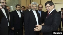 Turkey's Foreign Minister Ahmet Davutoglu [R] welcomes Iran's chief negotiator Saeed Jalili [2nd R] before their meeting in Istanbul, April 14, 2012.