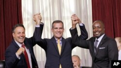 Le conseiller municipal de Los Angeles, Joe Buscaino, à gauche, le maire de Los Angeles Eric Garcetti et le conseiller Marqueece Harris-Dawson, célèbrent le vote du conseil municipal sur la candidature de la ville aux JO-2024, le 1er septembre 2015 à Los Angeles.