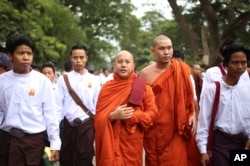 FILE - Nationalist Buddhist monk Wirathu, center, marches to celebrate newly imposed restrictions on interfaith marriages in Mandalay, the second largest city in Myanmar, Sept. 21, 2015.
