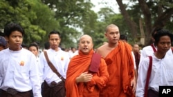 FILE - Nationalist Buddhist monk Wirathu, center, marches to celebrate newly imposed restrictions on interfaith marriages in Mandalay, the second largest city in Myanmar, Sept. 21, 2015. 