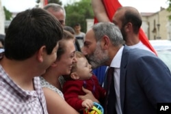 Armenia's Prime Minister Nikol Pashinian kisses a baby after a news conference in the capital Stepanakert of the separatist Nagorno-Karabakh region, May 9, 2018.