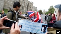 Un fanático de la realeza Royal lleva una pancarta en las afueras del Castillo de Windsor en Windsor, sur de Inglaterra, el lunes 6 de mayo de 2019, después de que el príncipe Harry anunció que su esposa Meghan, duquesa de Sussex, había dado a luz a un niño.