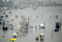 Seorang pria mengarungi bagian pantai Marina yang terendam banjir yang dipicu oleh hujan deras di Chennai, 9 November 2021. (Arun SANKAR / AFP)