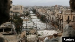 FILE - A general view shows damaged buildings along a deserted street and an area controlled by forces loyal to Syria's President Bashar Al-Assad, as seen from a rebel-controlled area at the Bab al-Nasr frontline in Aleppo, Feb. 10, 2015. 