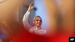 Cuba's President Raul Castro waves to workers as he watches the May Day march in Havana, Cuba, May 1, 2014.