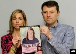 FILE - Kate and Gerry McCann pose with a missing poster, an age progression computer generated image of their daughter Madeleine at 9 years old, as they mark their daughter Madeleine's birthday and the fifth anniversary of her disappearance in London, May 2, 2012.