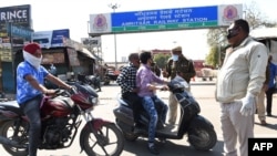Polisi mencegat pengendara motor di depan pintu masuk ke stasiun Kereta Api Amritsar saat berlangsungnya jam malam Janata (sipil) sebagai upaya pencegahan perebakan virus corona di Amritsar, 22 Maret 2020.