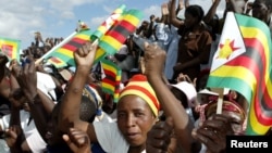 Zimbabwe political supporters wave flags in Gutu, a rural town 220 Km's south-east of the capital [Harare], (File photo).