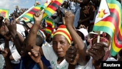 FILE - Zimbabwe political supporters wave flags in Gutu, a rural town 220 Km's southeast of the capital Harare.