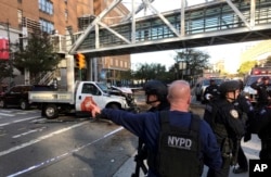 In this photo provided by the New York City Police Department, officers respond to a report of gunfire along West Street near the pedestrian bridge at Stuyvesant High School in lower Manhattan in New York, Oct. 31, 2017.