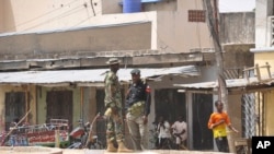 尼日利亞安全部隊2015年3月7日在邁杜古里市場的爆炸現場站崗