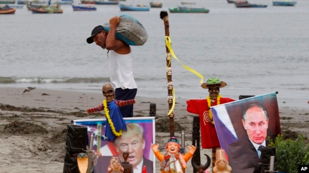 Dos líderes mundiales que preocupan al mundo. Un pescador pasa por delante de un altar con una imagen del presidente electo Donald Trump y del presidente ruso Vladimir Putin, creado por un grupo de chamanes para su ceremonia de Año Nuevo, en la playa Agua Dulce en Lima, Perú.