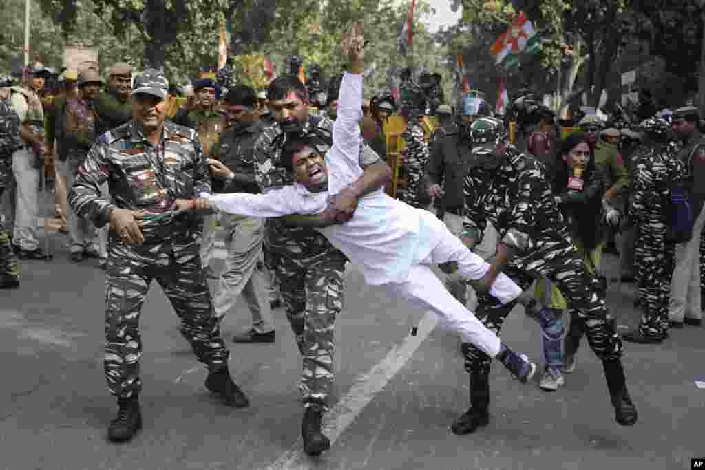 Paramilitary soldiers detain a Congress party supporter during a protest in New Delhi, India, against the withdrawal of Special Protection Group (SPG) cover to party president Sonia Gandhi, her immediate family members and former Prime Minister Manmohan Singh.