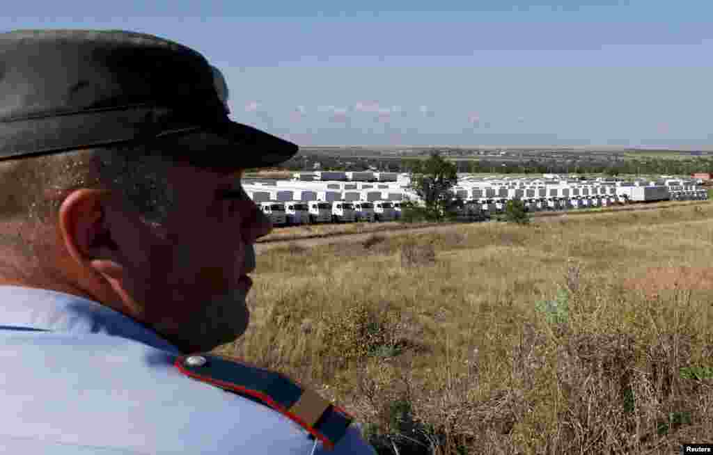 An Interior Ministry member surveys a Russian convoy carrying humanitarian aid to Ukraine, near Kamensk-Shakhtinsky, Rostov region, Aug. 21, 2014.