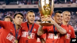 Chile's Edson Puch holds the championship trophy after the Copa America Centenario championship soccer match, Sunday, June 26, 2016.