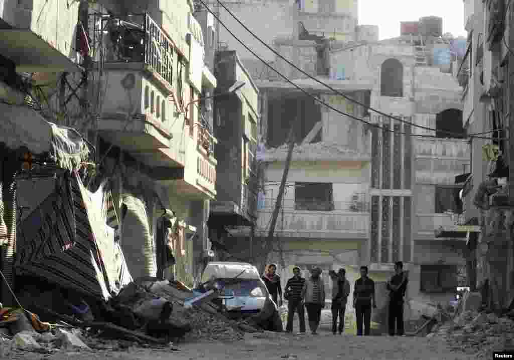 Free Syrian Army fighters inspect damages in Al-khalidiya neighbourhood in Homs October 18
