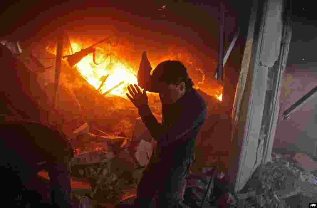 A man searches for people in a fire following airstrikes by Syrian government on the rebel-held besieged town of Douma in the eastern Ghouta region, on the outskirts of the capital Damascus.