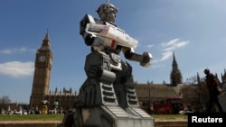 FILE - A mock killer robot is pictured in front of the Houses of Parliament and Westminster Abbey as part of the Campaign to Stop Killer Robots in London, April 23, 2013.