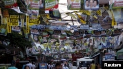 Election posters for the 2016 national elections hang above a busy road in Tondo, Manila, April 26, 2016. 